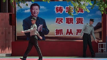 People's Liberation Army (PLA) soldiers are seen next to a poster with a picture of Chinese President Xi Jinping next to the entrance to the Forbidden City in Beijing on May 18, 2020. (AFP)