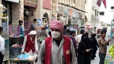 A man wears a protective face mask, following the outbreak of coronavirus, as he pushes a cart in souq Waqif in Doha. (File photo: Reuters)  2