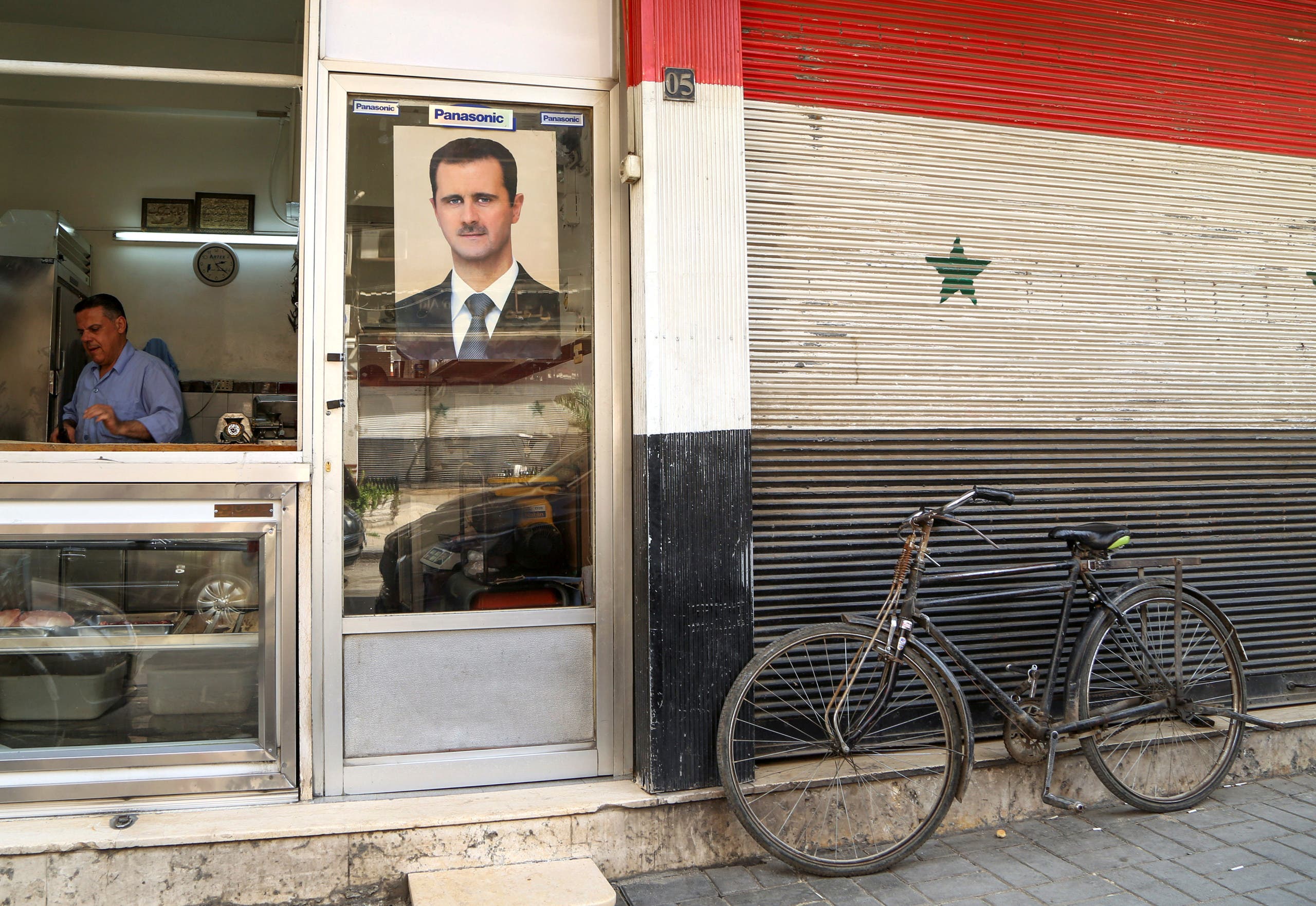 A picture of Syrian President Bashar al-Assad is seen on a door of a butcher shop, during a lockdown to prevent the spread of the coronavirus, in Damascus, Syria April 22, 2020. (Reuters)