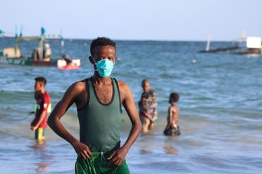 A man wears a mask as a protective measure to curb the coronavirus while bathing at Lido beach in Mogadishu, Somalia, on April 4, 2020. (AFP)