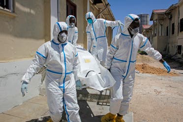 Medical workers in protective suits carry the body of a man who died of COVID-19, before he is buried in Mogadishu, Somalia on May, 13, 2020. (AP)