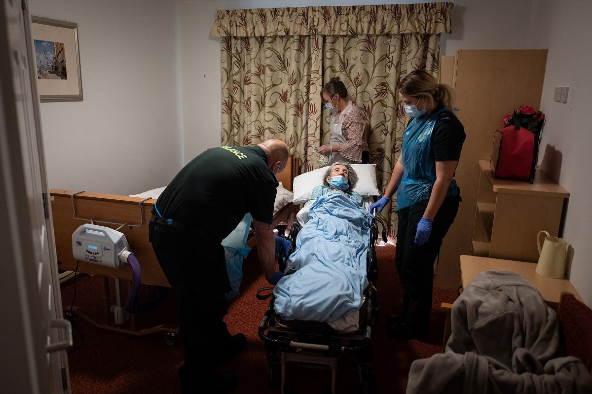 Medics help to settle an elderly non-COVID-19 patient into a care home after moving her from hospital near Portsmouth, south England on May 5, 2020. (AFP)