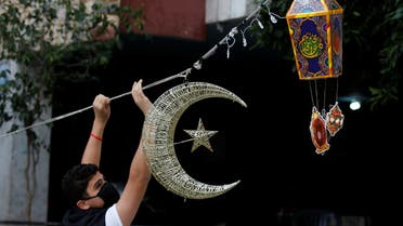 A man puts Ramadan decorations on a street ahead of the Muslim holy month of Ramadan, during a countrywide lockdown over the coronavirus disease (COVID-19) in Beirut. (Reuters)