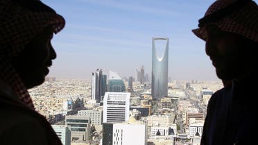 Men look out of a building as the Kingdom Centre Tower is seen in Riyadh, Saudi Arabia, January 1, 2017. (Reuters)