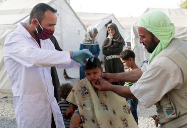 A volunteer hairdresser cuts the hair of an internally displaced boy at an IDP camp in Idlib, Syria May 19, 2020. (Reuters)