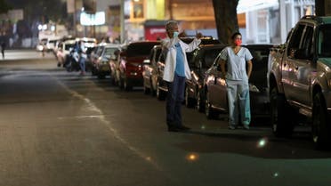 Doctors Carlos Martinez and Maria Martinez wait in line to get fuel at a gas station, during a nationwide quarantine due to the coronavirus disease (COVID-19) outbreak, in Caracas, Venezuela April 7, 2020. (Reuters)