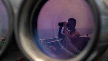 A US sailor uses binoculars to scan the ocean during a bridge watch aboard the guided-missile destroyer USS Bainbridge (DDG 96) in the Gulf, in this undated handout picture released by US Navy on August 3, 2019. (Reuters)