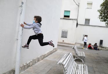 Kilian, 6, wears a protective face mask as he jumps from a bench, after restrictions were partially lifted for children, during the coronavirus disease (COVID-19) outbreak, in Igualada, Spain April 26, 2020. (Reuters)