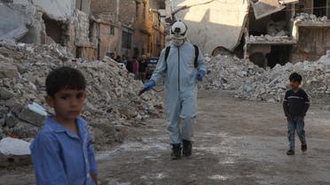 A member of the Syrian civil defense, also known as the White Helmets, disinfects a destroyed neighborhood in Atareb town of Syria’s Aleppo province on May 7, 2020. (AFP)