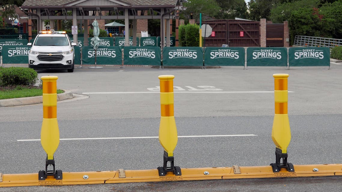 Barricades and a security vehicle block the entrance to a closed Disney Springs Monday, May 18, 2020, in Lake Buena Vista, Fla. As Walt Disney World shops and restaurants prepare to open at its entertainment complex later this week, it's posting a warning about the dangers of coronavirus advising guests that they voluntarily assume all risks related to exposure to COVID-19. (AP Photo/(John Raoux)