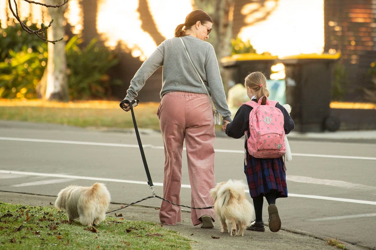 A school girl and her mum make their way to school after the government allowed schools to re-open under Level 2 guidelines in Wellington on May 18, 2020. (AFP)