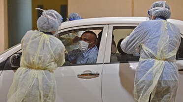 Health workers perform a nose swab test during a drive through coronavirus test campaign held in Diriyah hospital in the Saudi capital Riyadh on May 7, 2020 amid the COVID-19 pandemic. 