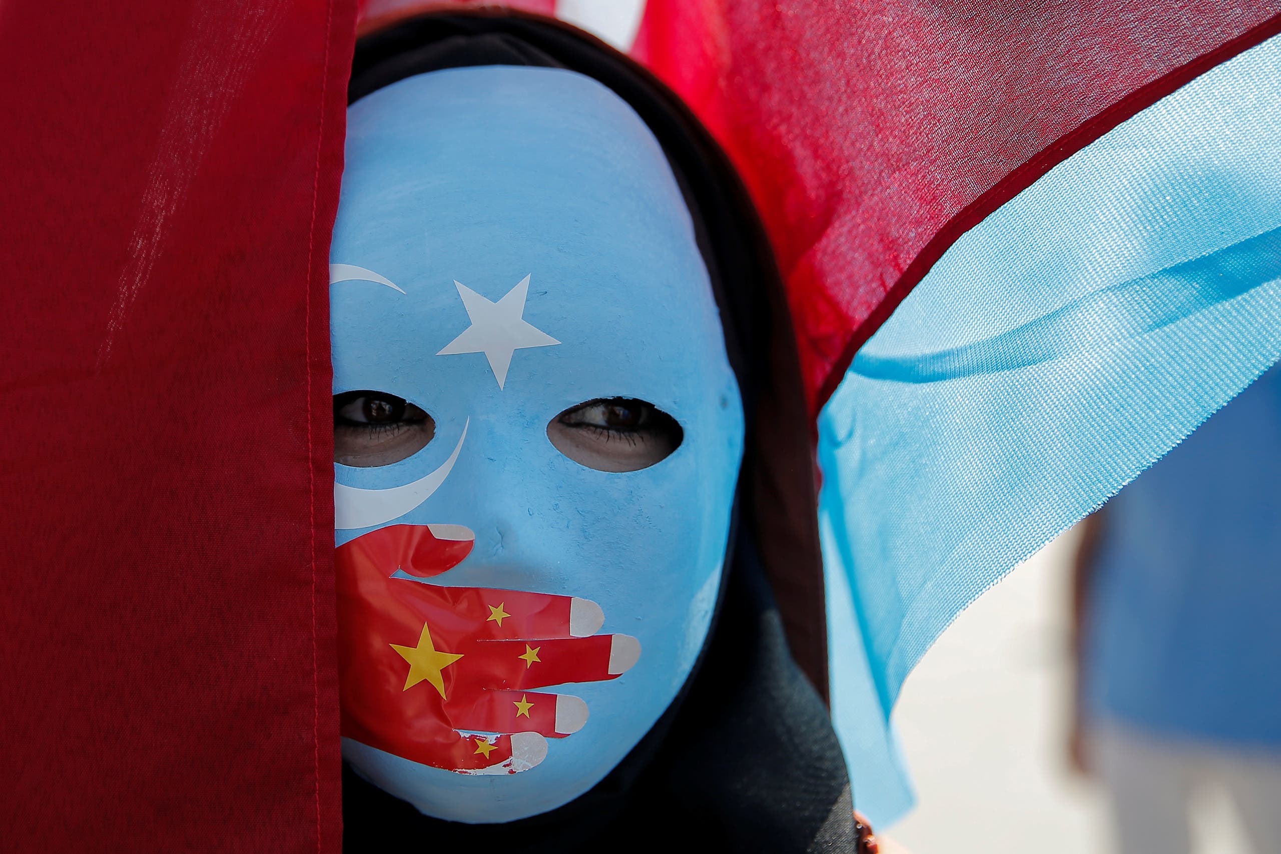 An ethnic Uighur demonstrator wears a mask as she attends a protest against China in front of the Chinese Consulate in Istanbul. (File photo: Reuters)