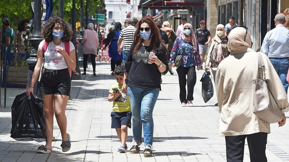 Tunisians walk in the Habib Bourguiba avenue in the Tunisian capital Tunis on May 12, 2020, following the easing of the lockdown measures to combat the spread of coronavirus. (AFP)