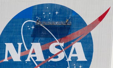 Workers pressure wash the logo of NASA on the Vehicle Assembly Building before SpaceX will send two NASA astronauts to the International Space Station aboard its Falcon 9 rocket, at the Kennedy Space Center in Cape Canaveral, Florida, U.S., May 19, 2020. (Reuters)