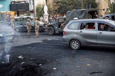 Commuters travelling in a taxi look at the remains of burned tires during ongoing anti-government protests in Jal el-Dib, Lebanon November 13, 2019. (Reuters)