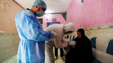 A healthcare worker takes blood samples from a woman during testing for the coronavirus disease (COVID-19) in Sadr city, district of Baghdad, Iraq May 21, 2020. REUTERS/Thaier Al-Sudani