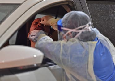 Health workers perform nose swab tests during a drive through coronavirus test campaign held in Diriyah hospital in the Saudi capital Riyadh on May 7, 2020 amid the COVID-19 pandemic. 