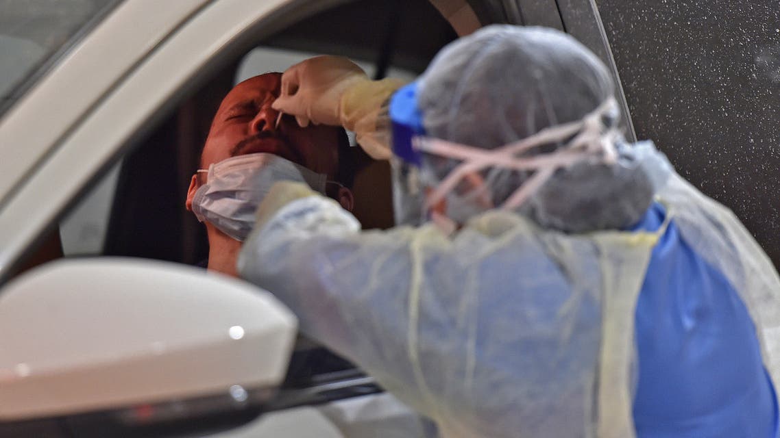 Health workers perform nose swab tests during a drive through coronavirus test campaign held in Diriyah hospital in the Saudi capital Riyadh on May 7, 2020 amid the COVID-19 pandemic.