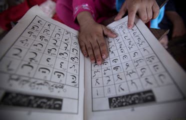 A Pakistani girl reads the Arabic alphabet on the outskirts of Islamabad, Pakistan on Aug. 15, 2011. (AP)