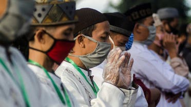 Indonesian Muslims wear protective face masks and plastic gloves as they pray at a mosque during Eid al-Fitr on May 24, 2020. (Reuters)