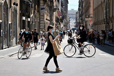 A woman wearing a protective mask walks in via Del Corso central Rome, on May 23, 2020. (AFP)