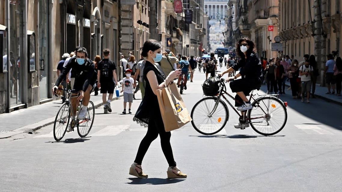 A woman wearing a protective mask walks in via Del Corso central Rome, on May 23, 2020. (AFP)