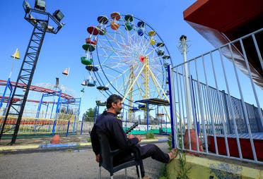 A security guard sits at an empty amusement park, on the first day of the Muslim holiday of Eid al-Fitr, in Sidon, southern Lebanon. (Reuters)
