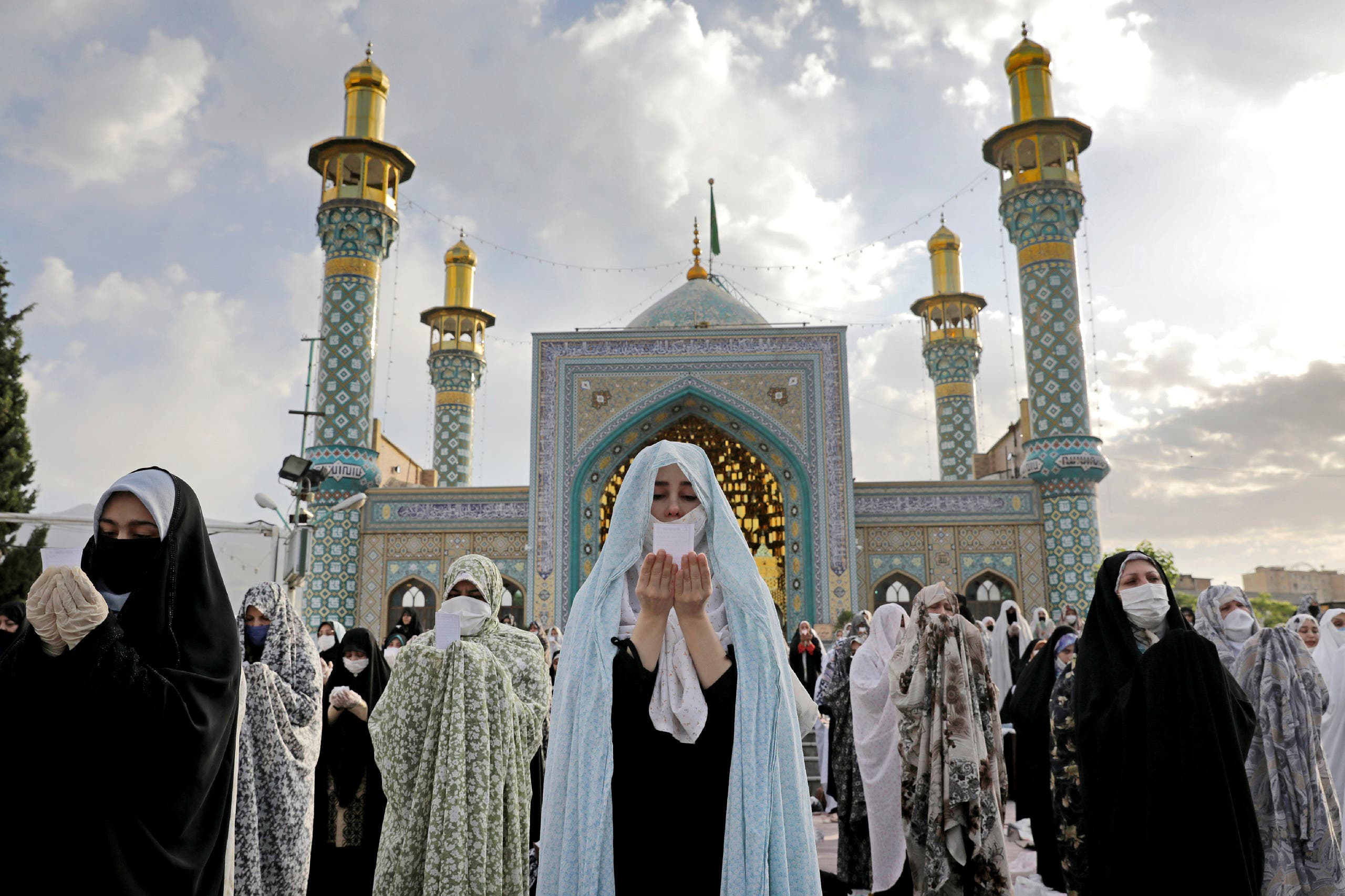 Worshippers wearing protective face masks offer Eid al-Fitr prayers outside a shrine to help prevent the spread of the coronavirus, in Tehran, Iran on May 24, 2020. (AP)