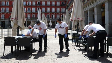 Workers use measuring tape to check social distancing as they set up a terrace which will be allowed to open from May 25, amid the coronavirus disease (COVID-19) outbreak, at Plaza Mayor Square in Madrid, Spain, May 24, 2020. (Reuters)