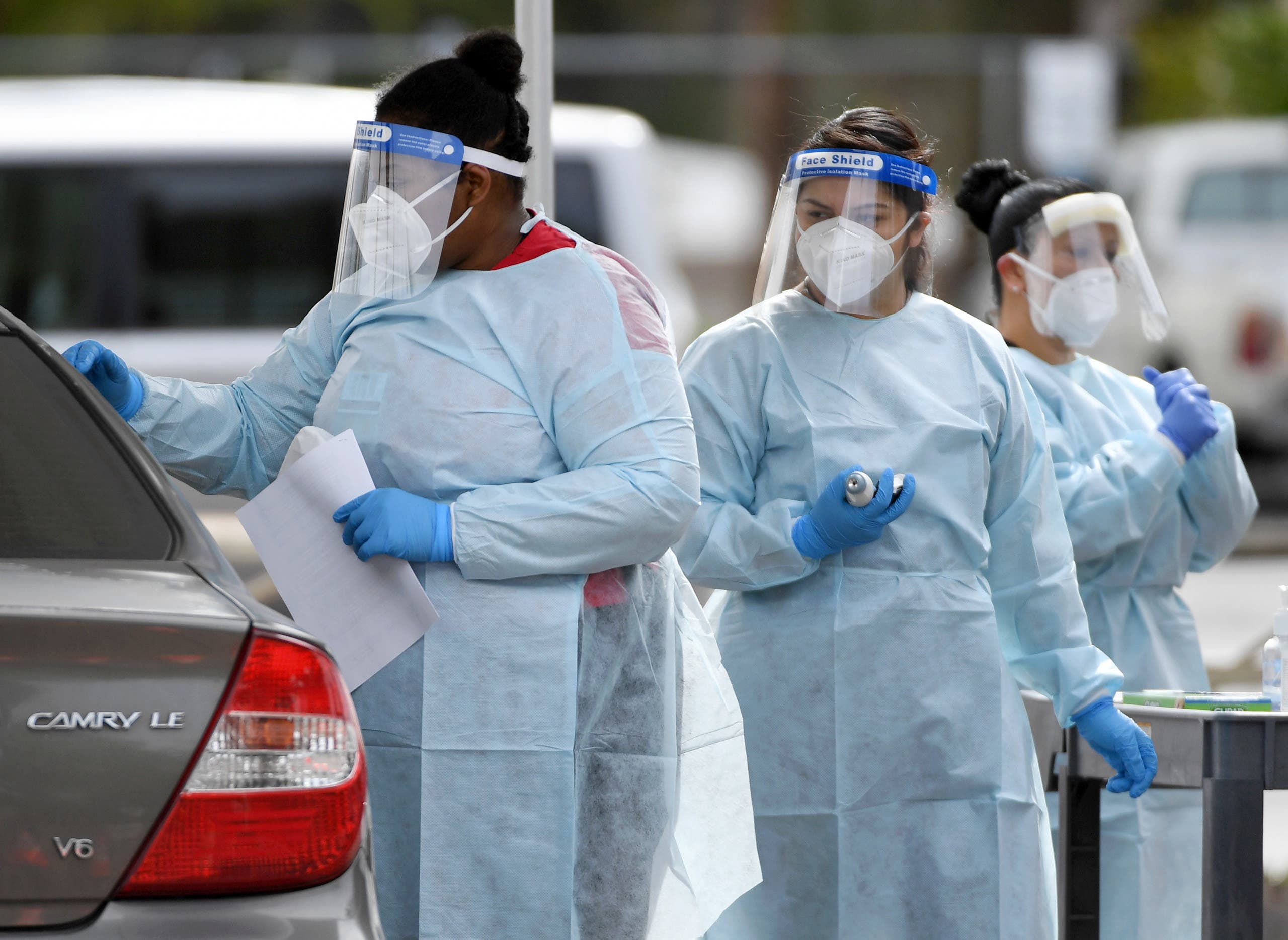 Certified medical assistants Lakietha Flourney, Yatziri Perez and Evelyn Laolagi conduct tests for COVID-19 at a drive-up testing station in the parking lot of UNLV Medicine on April 6, 2020 in Las Vegas, Nevada, US. (AFP)