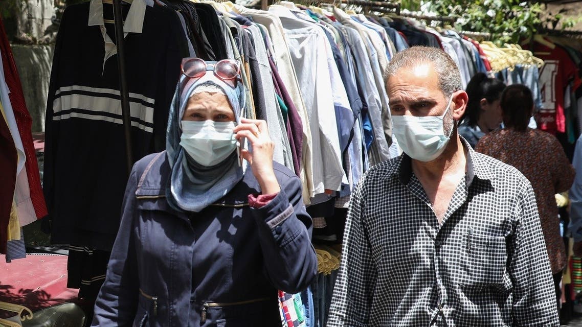 Mask-clad Syrians shop for clothes at a flea market in the capital Damascus on May 17, 2020. (AFP)