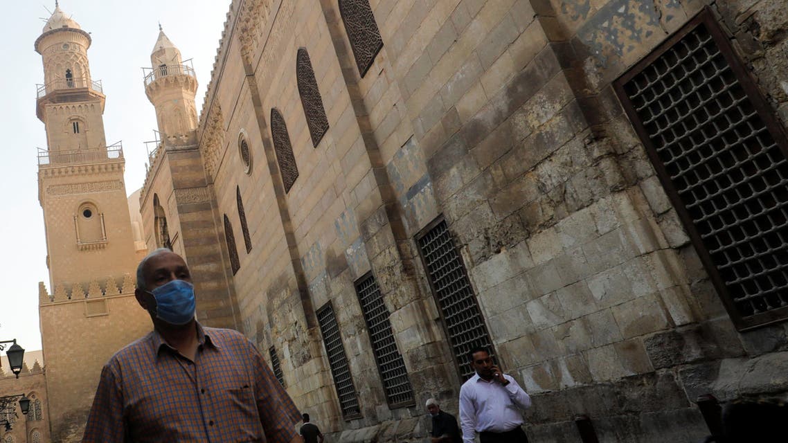 A man wearing a protective face mask, amid concerns over the coronavirus disease (COVID-19), walks next to others before iftar, or breaking fast, during the holy month of Ramadan in front of closed mosques and Islamic schools at El Moez Street in old Islamic Cairo, Egypt April 30, 2020. REUTERS/Amr Abdallah Dalsh