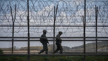 (FILES) This file photo taken on April 23, 2020 shows South Korean soldiers patrolling along a barbed wire fence Demilitarized Zone (DMZ) separating North and South Korea, on the South Korean island of Ganghwa. North Korean troops fired multiple gunshots towards the South in the Demilitarized Zone dividing the peninsula on May 3, 2020, prompting South Korean forces to fire back, Seoul said.