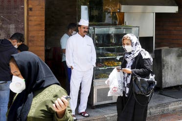 Iranians pass by a restaurant in the capital city of Tehran, on May 26, 2020. (AFP)