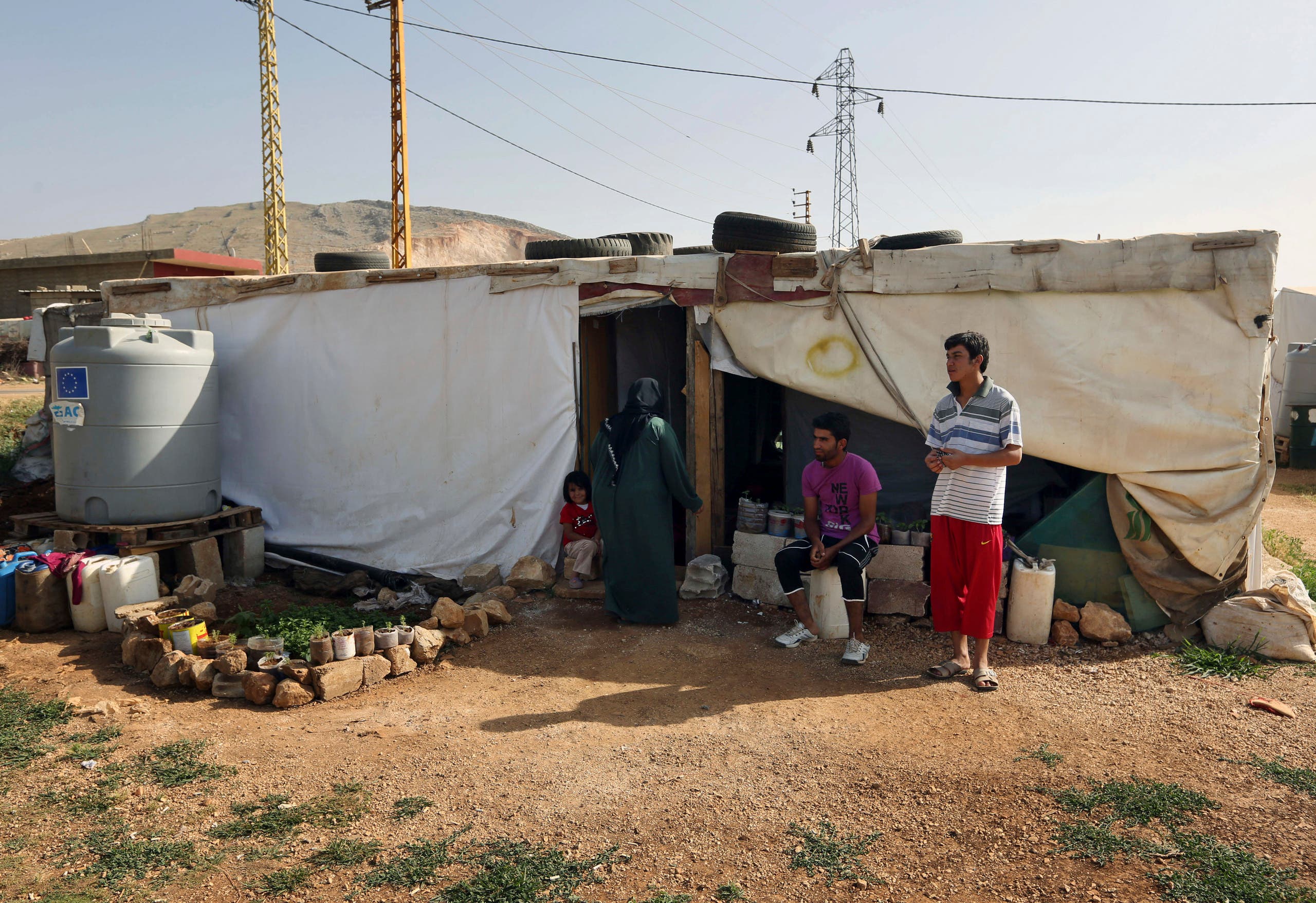 Syrian refugees stand outside their tent at a Syrian refugee camp in the eastern Lebanese town of Majdal Anjar, Lebanon. (File photo: AP)