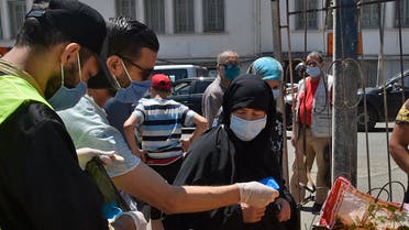 Algerians receives masks distributed by volunteers from the civil society, in a neighbourhood of the capital Algiers on May 21, 2020, as the threat of infections by the COVID-19 caused by the novel coronavirus lingers in the country. 
