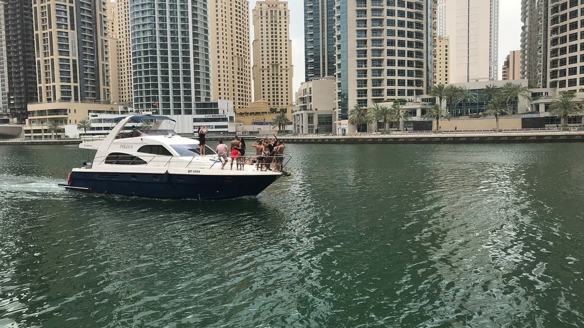 People react as they take pictures on a yacht during the first day of Eid al-Fitr, following the outbreak of the coronavirus disease (COVID-19), in Dubai. (Reuters)