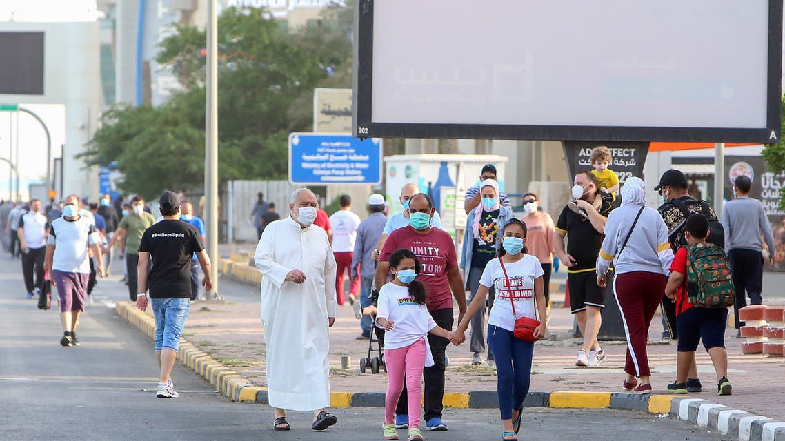 Mask-clad residents walk in a neighbourhood of Kuwait City on May 12, 2020, as authorities allowed people to exercise for two hours under a nationwide lockdown due to the COVID-19 pandemic.