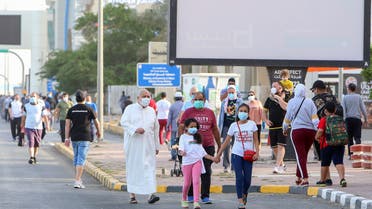 Mask-clad residents walk in a neighbourhood of Kuwait City on May 12, 2020, as authorities allowed people to exercise for two hours under a nationwide lockdown due to the COVID-19 pandemic. 