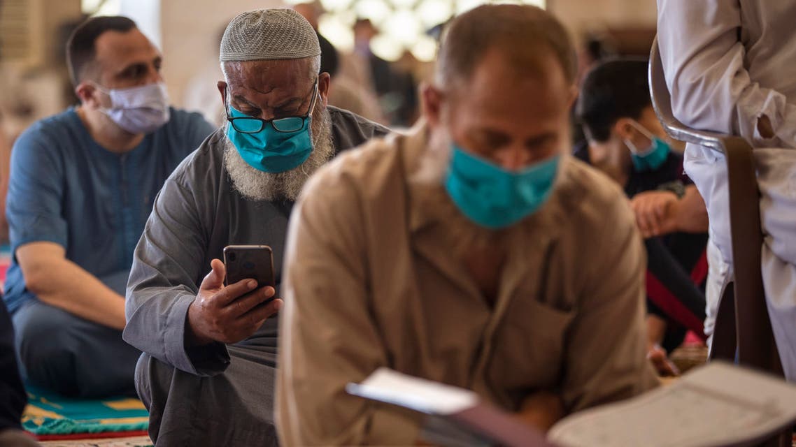 Palestinians wearing face masks read the Quran as they attend the last Friday noon Prayer of the holy month of Ramadan, in a mosque in Gaza City, Friday, May. 22, 2020. After nearly two months of closure due to the coronavirus, Gaza's Hamas rulers decided to partially reopen mosques for the Friday noon prayer. (AP Photo/Khalil Hamra)