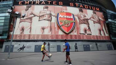 People play football outside the stadium at the time the final match of season between Arsenal and Watford was due to take place before it was postponed. (Reuters)