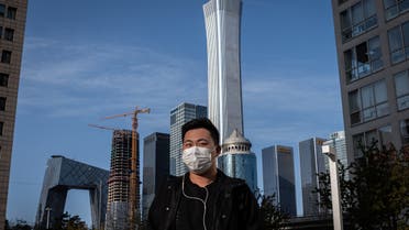 A man wearing a face mask amid the COVID-19 coronavirus outbreak walks outside office buildings in Beijing on April 1, 2020. (AFP)