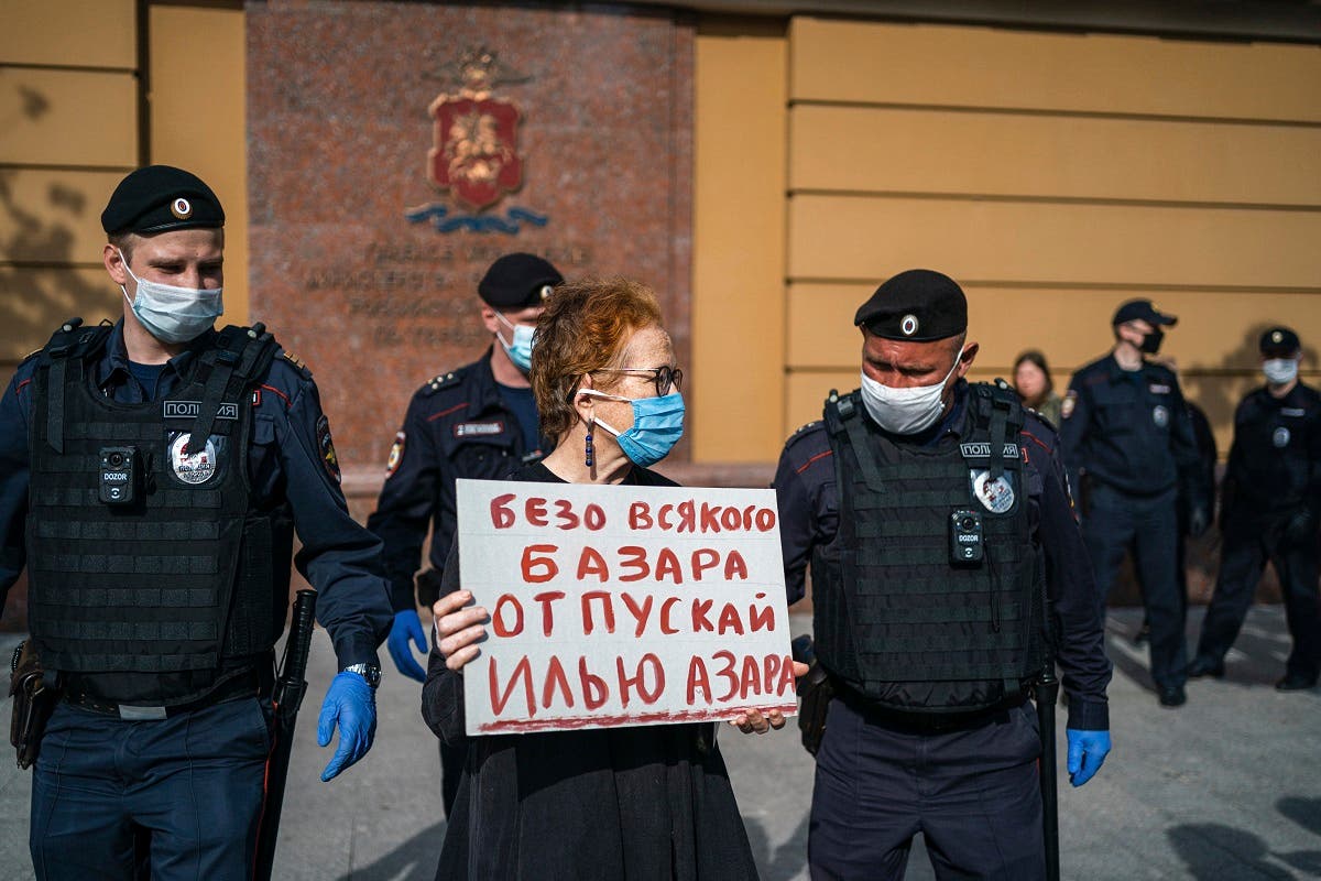 Police officers detain Russian photographer Victoria Ivleva (C) during a solo picket in support of journalist and activist Ilya Azar outside the Moscow police headquarters in Moscow on May 28, 2020. (AFP)