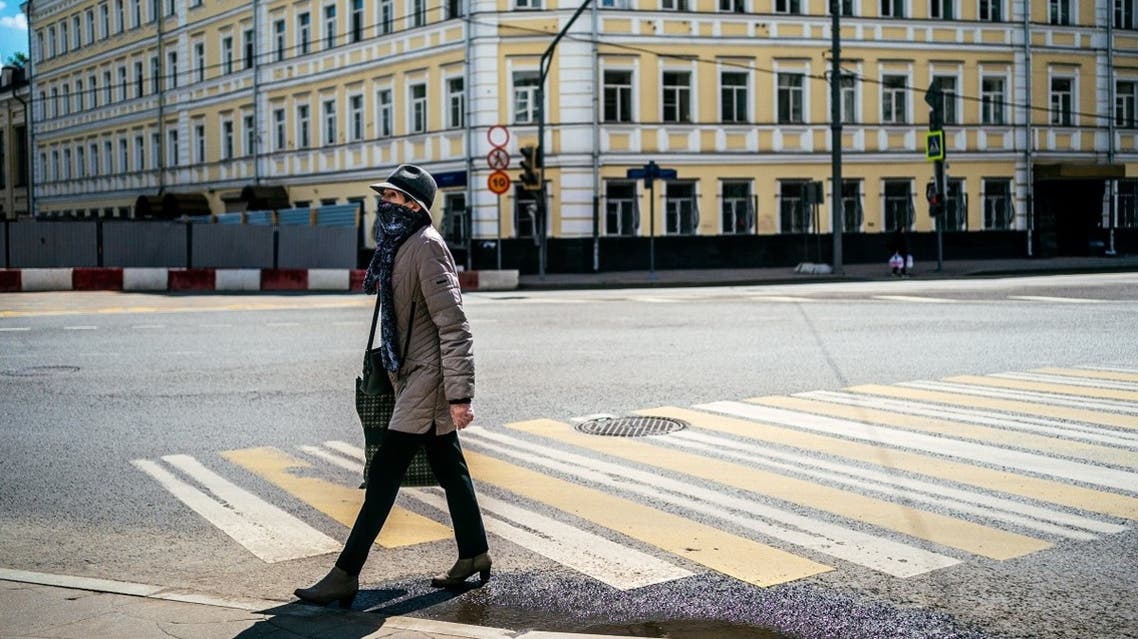 A woman wearing a protective face mask walks across a street in Moscow on May 28, 2020. (AFP)