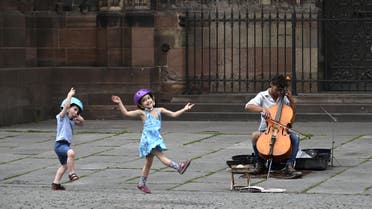 Two children dance as they listen to a street musician on May 22, 2020 in Strasbourg, eastern France. (AFP)
