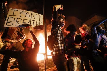 Protestors demonstrate outside of a burning Minneapolis 3rd Police Precinct, Thursday, May 28, 2020, in Minneapolis. Protests over the death of George Floyd, a black man who died in police custody Monday, broke out in Minneapolis for a third straight night. (AP)