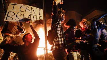 Protestors demonstrate outside of a burning Minneapolis 3rd Police Precinct, Thursday, May 28, 2020, in Minneapolis. Protests over the death of George Floyd, a black man who died in police custody Monday, broke out in Minneapolis for a third straight night. (AP)