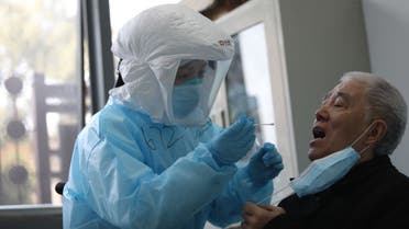 A medical worker takes a swab from a previously recovered COVID-19 coronavirus patient during testing at a hospital in Wuhan, in China's central Hubei province on March 14, 2020. (AFP)