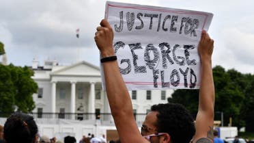 Protesters hold signs as they gather outside the White House in Washington, DC, on May 29, 2020 in a demonstration over the death of George Floyd. (AFP)